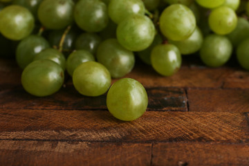 Green grape on wooden table on wooden background