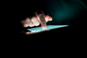 Man using a tablet in the dark