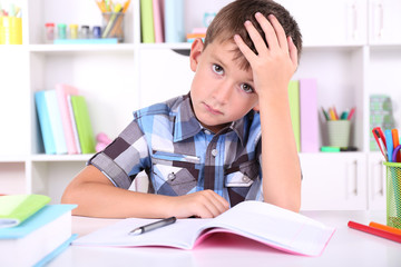 Schoolboy sitting at table in classroom