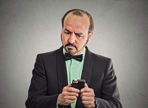 puzzled confused businessman looking at smartphone