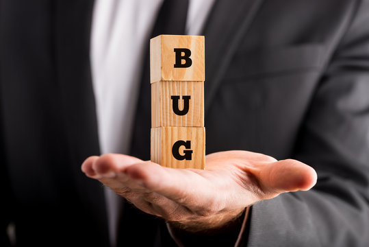 Businessman holding wooden blocks with the word Bug