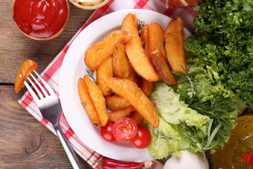 Homemade fried potato on plate on wooden background