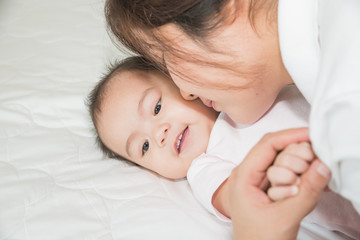 Happy cheerful family. Asian mother and baby kissing, laughing a