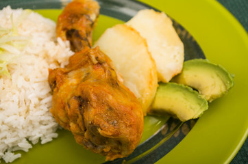 chicken served with white rice potato on a plate