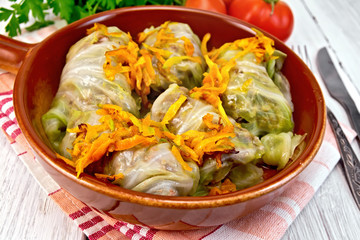Cabbage stuffed with sauerkraut in ceramic pan on board