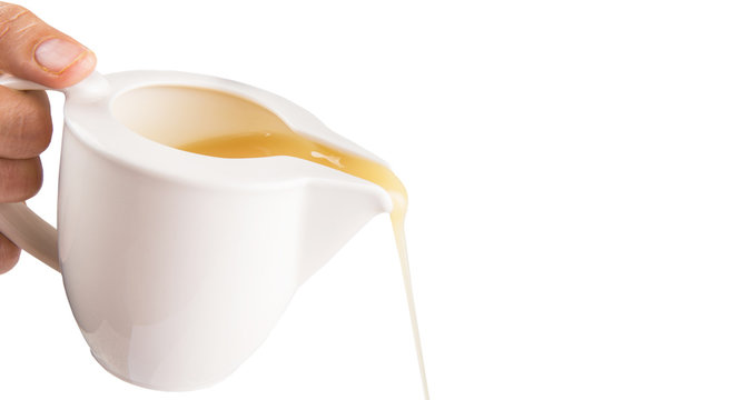 Female hand pouring condensed milk over white background