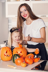 Kid on Halloween party making carved pumpkin with a little help 