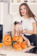 Kid on Halloween party making carved pumpkin with a little help 