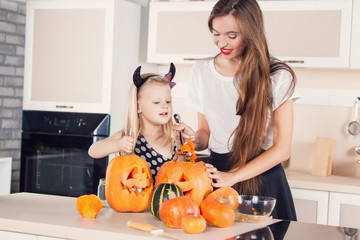 Kid on Halloween party making carved pumpkin with a little help 