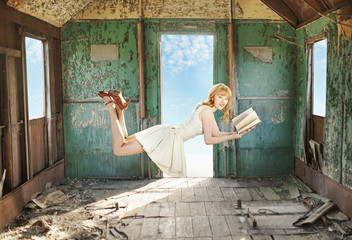 Glad levitating redhead with the book