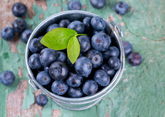 fresh blueberries in a bucket on wooden surface