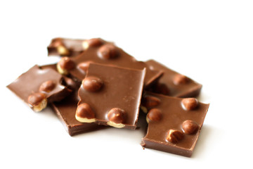 Chocolate pieces with nuts on white background