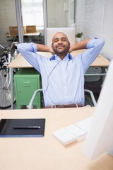 Relaxed businessman listening music at desk
