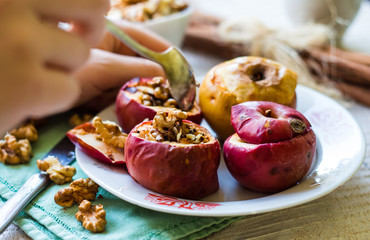 eating baked apples with walnuts, honey and cinnamon, dessert
