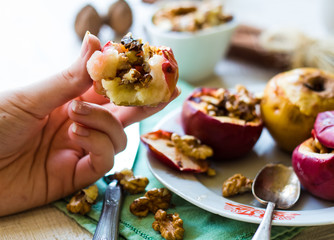 eating baked apples with walnuts, honey and cinnamon, dessert
