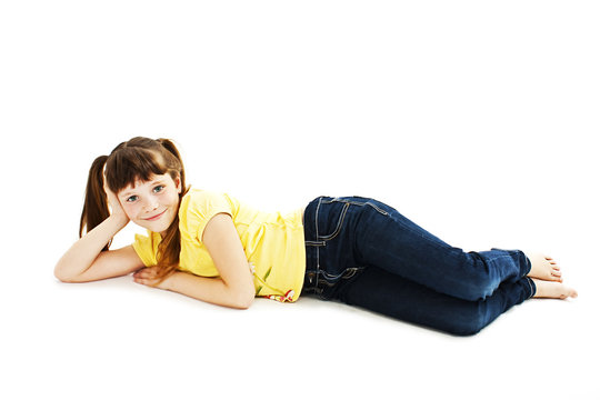 Pretty little girl lying on the floor in jeans