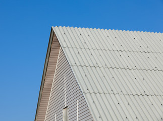 Fototapeta na wymiar Brand new roof slate roofing against blue sky