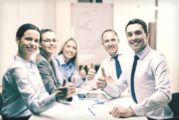 business team showing thumbs up in office