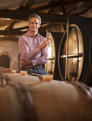 Professional winemaker tasting a glass of white wine in his trad