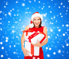 smiling woman in red dress with gift boxes