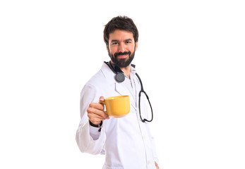 Doctor holding a cup of coffee over white background