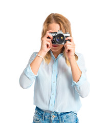 Blonde woman photographing over white background