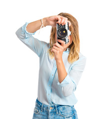 Blonde woman photographing over white background