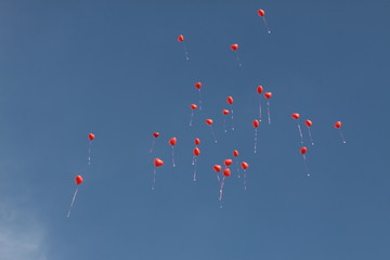 Viele rote Luftballons steigen in den Himmel hoch