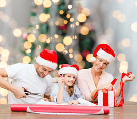 happy family in santa helper hats packing gift