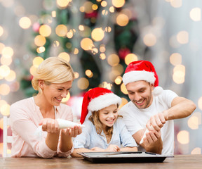 happy family in santa helper hats cooking
