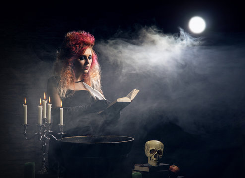 Witch making witchcraft on a smoky Halloween background