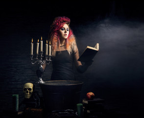 Beautiful witch making witchcraft on a Halloween background