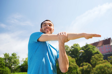 smiling man stretching outdoors