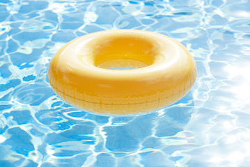 floating ring on blue water swimpool with waves reflecting