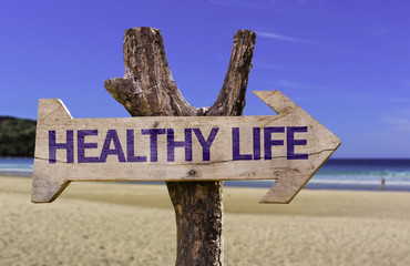 Healthy Life wooden sign with a beach on background