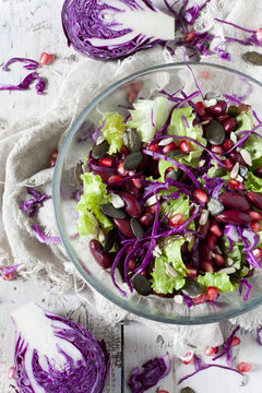 mixed salad on bowl with red beans, seeds and purple cabbage