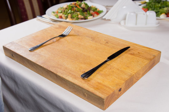 Fork and Knife on Wooden Chopping Board