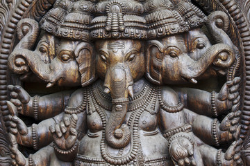 A close up of a carved wodden Ganesha with many details