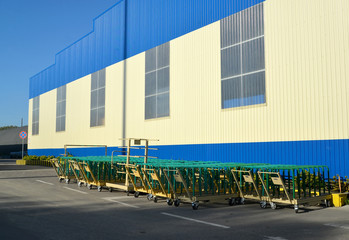 Fototapeta na wymiar Cargo carts stand near the building of modern plant