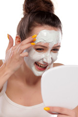 young woman enjoys applying face mask