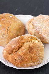 bread on white dish on dark background