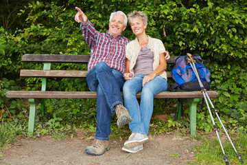 Paar Senioren sitzt auf Bank bei Wanderung