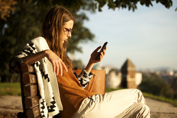 Fashion Young Girl Using Smart Phone On Bench In Park