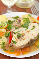 fish stew on white plate with white wine