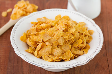 corn flake in white dish on brown background