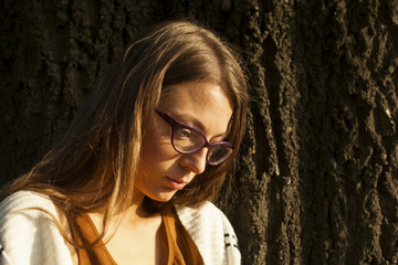 Young Girl Fashion Portrait With Glasses Leaning On Tree