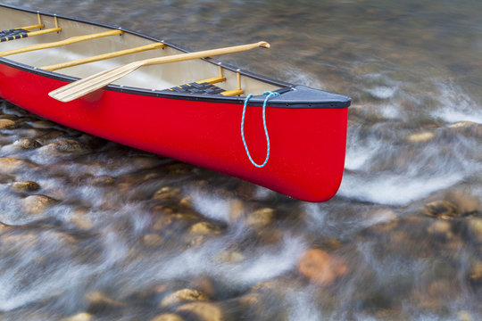 red canoe on a shallow river