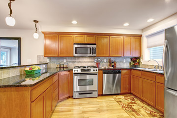 Maple kitchen cabinets with steel appliances and granite tops