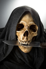 Death Skeleton head hold knife in mouth
