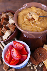 Fondue, slices of cheese, tomatoes and biscuits